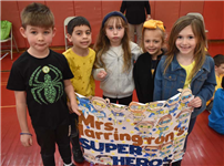 Students standing together and holding a sign while smiling thumbnail244961